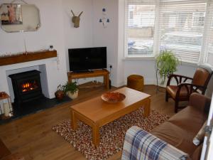 a living room with a table and a fireplace at Anchor Cottage in Cleethorpes