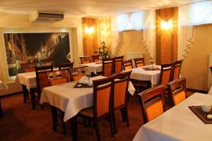 a restaurant with tables and chairs with white tablecloths at Hotel Linder in Malnia