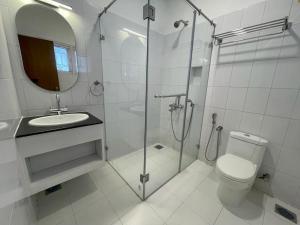 a bathroom with a shower and a toilet and a sink at Hanu Reddy Residences - Nawab Habibullah Avenue in Chennai