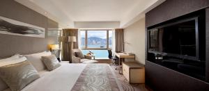Habitación de hotel con cama y TV de pantalla plana. en The Royal Garden en Hong Kong
