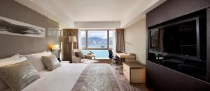 una camera con letto e TV a schermo piatto di The Royal Garden a Hong Kong