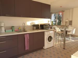 uma cozinha com uma máquina de lavar roupa e um lavatório em Pool House Matisse in großem Park mit geheizten Pool em Châteauneuf