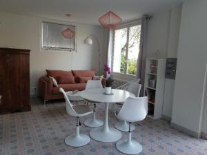 uma sala de estar com uma mesa e cadeiras e um sofá em Pool House Matisse in großem Park mit geheizten Pool em Châteauneuf