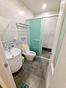 a bathroom with a toilet and a sink and a shower at Rainy Pleasure in Meishan