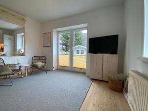 a living room with a flat screen tv on a wall at Kalle Blomquist in Hörnum