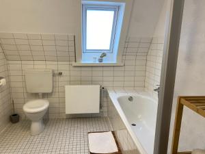 bagno con servizi igienici, vasca e finestra di Kalle Blomquist a Hörnum Altre 18 foto