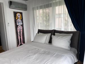 a bed in a bedroom with a painting on the wall at Studio Cuzino 106 Pipera in Voluntari