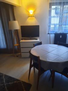 sala de estar con mesa y TV en Studio rénové au cœur du village, en Saint-Martin-Vésubie