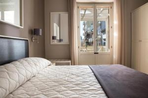 a bedroom with a large bed and a window at Faro Bianco Gallipoli - Suites & Apartments in Gallipoli