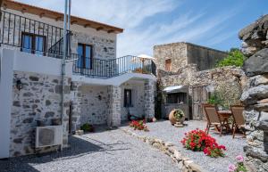 a stone house with a balcony and a patio at Villa Sunshine Crete in Vathiakón