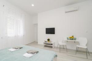 a white room with a bed and a tv at Apartment Rafaello in Dubrovnik