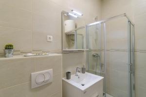 a white bathroom with a sink and a shower at Apartment Rafaello in Dubrovnik