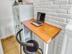 un ordinateur portable installé au-dessus d'un bureau en bois dans l'établissement Super OYO 90828 Ara Guest House, à Batu