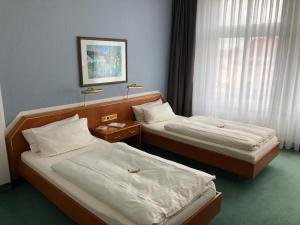 um quarto com duas camas e uma janela em Hotel Kaiserhof em Fürstenwalde