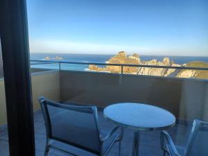 a table and chairs on a balcony with a view of the ocean at La Venta del Mar in Liencres