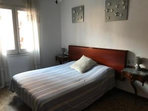 タラゴナにあるRamón y Cajal - Aptのベッドルーム1室(木製ヘッドボードと窓付)