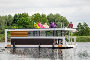 un bateau sur l'eau avec un homme en haut dans l'établissement Hausbót na Vltavě, à Hradišťko