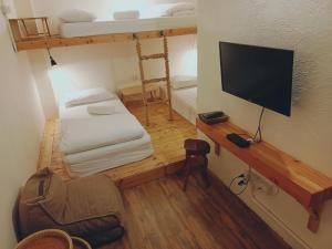 a small room with two bunk beds and a television at Sattahiptale Boutique Guesthouse & Hostel in Sattahip