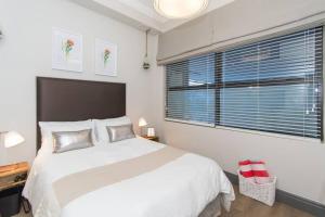 Un dormitorio con una gran cama blanca y una ventana en 9 Church View - No LoadShedding - Homely Apartment, en Ciudad del Cabo