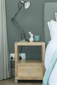 a lamp on a night stand next to a bed at 9 Church View - No LoadShedding - Homely Apartment in Cape Town