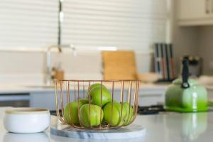 uma tigela de maçãs verdes num balcão na cozinha em 9 Church View - No LoadShedding - Homely Apartment na Cidade do Cabo