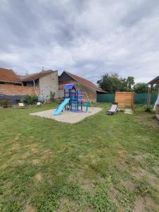 einen Spielplatz mit einer blauen Rutsche im Hof in der Unterkunft Mobilheim v LVA 2 in Podivín