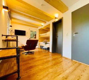 a living room with a chair and a desk at RotmeerHaus in Feldberg