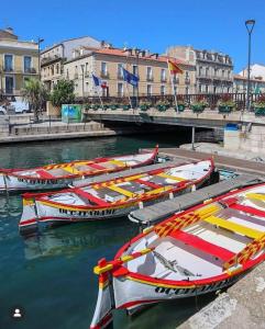 cuatro barcos están atracados en el agua junto a los edificios en studio mezzanine vue mer terrasse et parking en Sète