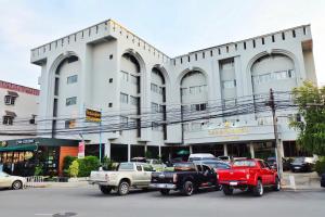 dos camiones estacionados frente a un edificio en U-Thong Hotel, en Phitsanulok