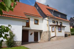 a white house with an orange roof at Ferienwohnungen Rießling in Elend