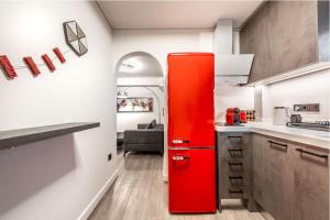 a red refrigerator in a kitchen with a couch at Brand-New , Delux apt in Central Athens! in Athens