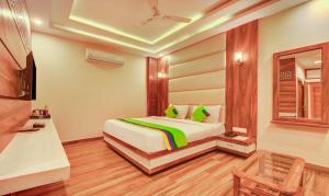 德拉敦Treebo G K Residency Near Dehradun Railway Station的一间带床和镜子的酒店房间