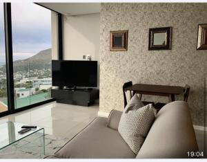 salon z kanapą i telewizorem z płaskim ekranem w obiekcie Lovely 1 bedroom apartment w Kapsztadzie