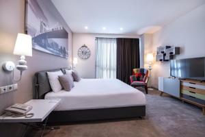 a hotel room with a large bed and a desk at Opera Suite Hotel in Yerevan