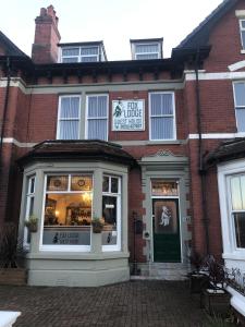 een winkel voor een bakstenen gebouw met een groene deur bij Fox lodge in Blackpool