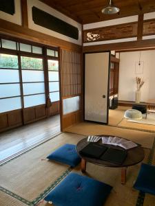 una habitación con una mesa y algunas alfombras azules en uminca ウミンカ, en Numazu