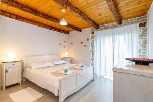 a bedroom with a large white bed and a window at Holiday Home Eufemia in Bale