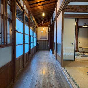 an empty hallway with glass doors and a wooden floor at uminca ウミンカ in Numazu