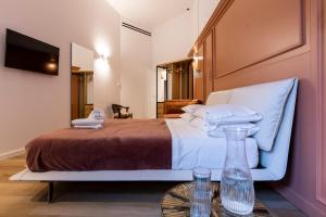 a bedroom with a bed and a table with glasses on it at Vespri Luxury Rooms & Suites in Palermo
