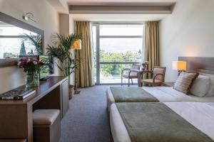 a hotel room with a bed and a large window at Amalia Hotel Athens in Athens +53 photos