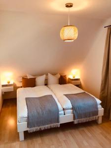 - une chambre avec 2 lits et une lampe pendant dans l'établissement Ferienwohnung Zur Schoritzer Wiek, à Groß Schoritz