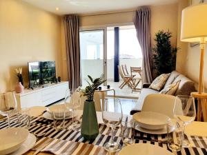 a living room with a couch and a table with wine glasses at Cozy Apartment on the Beach in Sitio de Calahonda