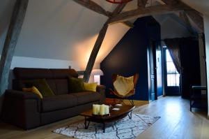 a living room with a couch and a table at La Charmeraie Wellness & SPA in Lacroix-Saint-Ouen