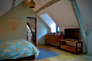 a bedroom with a bed and a dresser and a television at La Charmeraie Wellness & SPA in Lacroix-Saint-Ouen