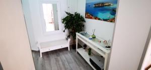 La salle de bains blanche est pourvue d'un lavabo et d'un miroir. dans l'établissement Perla del Sud - Guest House, à Lampedusa