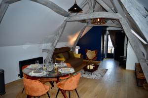 uma sala de estar com uma mesa e cadeiras e um sofá em La Charmeraie Wellness & SPA em Lacroix-Saint-Ouen