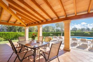 um pátio com uma mesa e cadeiras e uma piscina em Villa Marina de Namer By SunVillas Mallorca em Pollença
