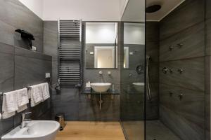 a bathroom with a sink and a glass shower at Vespri Luxury Rooms & Suites in Palermo +57 photos