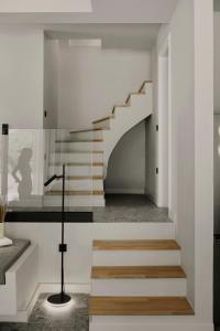 eine Treppe in einem Haus mit weißen Wänden und Holztreppe in der Unterkunft Aposperia Memorable Living in Kyra Panagia