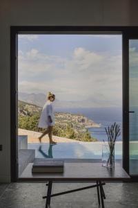 a woman walking on the balcony of a house at Aposperia Memorable Living in Kyra Panagia